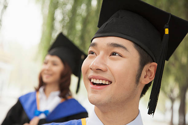 istock Two Young University Graduates Looking Away, Man in Front 455670211