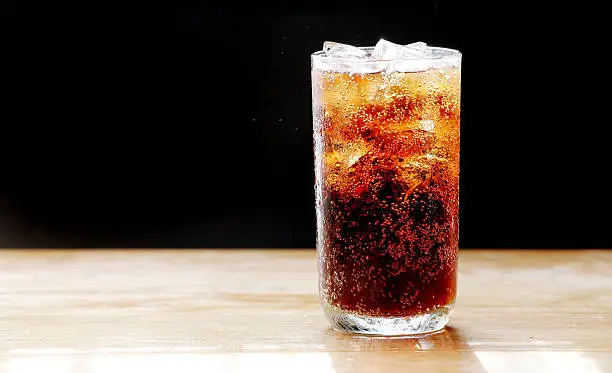 cola and ice,bubble in glass, black background.