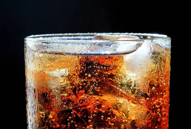 cola and ice,bubble in glass, black background.