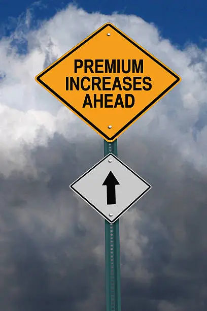 premium increases ahead road sign over dark blue sky with clouds