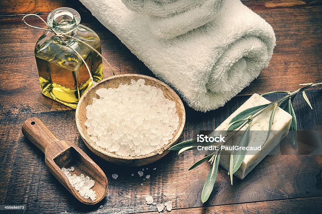 Spa setting with natural olive soap and sea salt Spa setting with natural olive soap and sea salt on wooden table Exfoliation Stock Photo