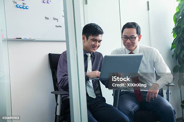 Two Colleagues Working Together Stock Photo - Download Image Now - Businessman, Chinese Ethnicity, Discussion