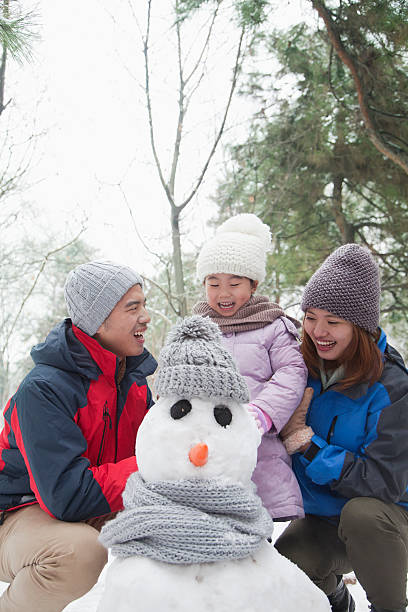 istock Family making snowman in winter 455690143