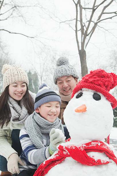istock Family making snowman in winter 455690285