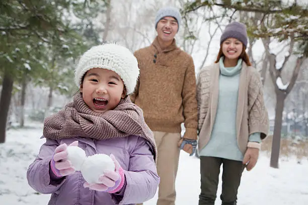 Photo of Young girl carrying snow balls in winter