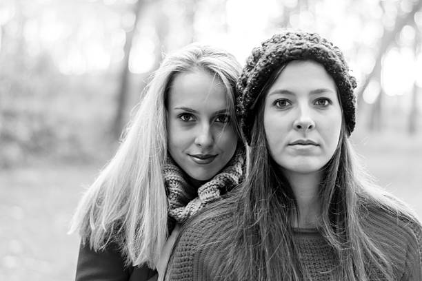 Two young fashion teen girls walking in autumn park