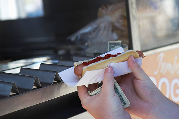 istock Customer holding a hot dog purchased. 455770589