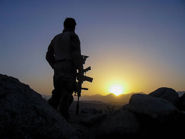 special forces soldat mit blick auf den sonnenuntergang - war symbols of peace conflict army stock-fotos und bilder