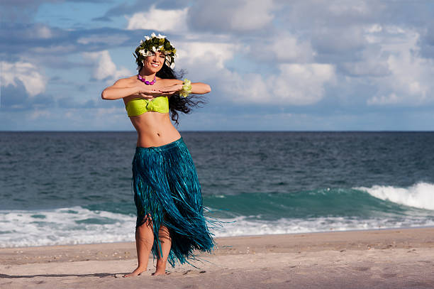 Beautiful, Smiling Hula Dancer on Beach A beautifu, happy hula dancer poses on the beach. hula dancer stock pictures, royalty-free photos & images