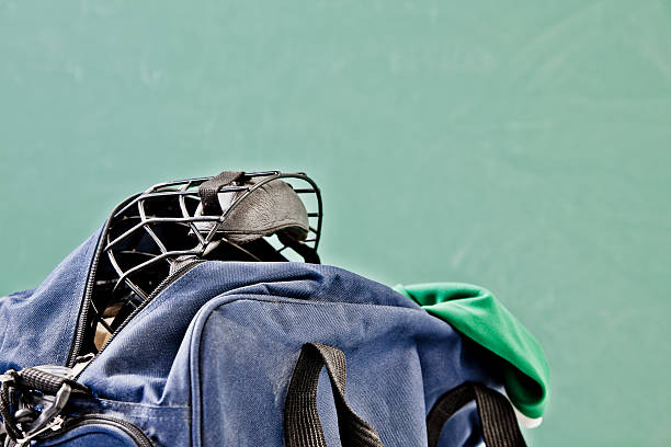 Hockey mask inside player's gym bag. Locker room with chalkboard background.