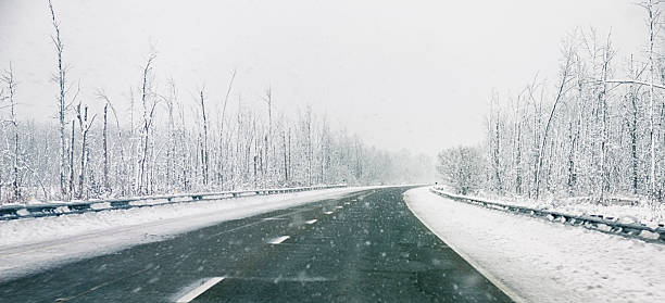 istock Driving in winter weather, windshield view of empty road 455843035