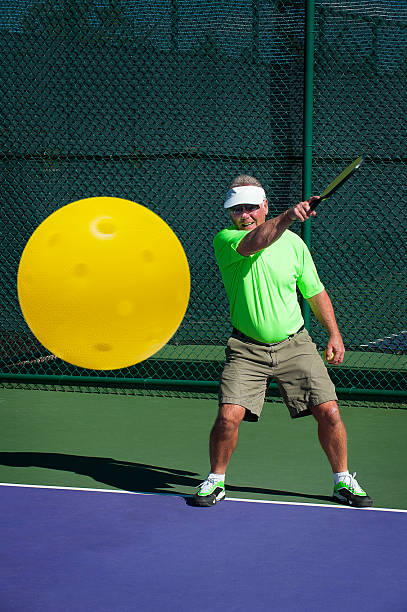 Pickleball Action - Senior Male Player Hitting Forehand with Smile