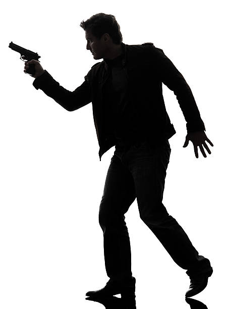 istock man killer policeman holding gun walking silhouette 455998083