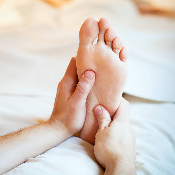 istock Hands massage foot on white duvet cover 456006263