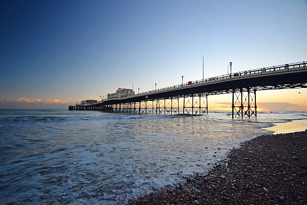Sunset Behind Worthing's Victorian Pier and Ocean Winter Sunset Behind Worthing's Victorian Pier and Ocean brightly lit winter season rock stock pictures, royalty-free photos & images