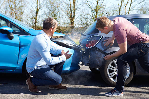 Two Drivers Arguing After Traffic Accident Two Drivers Arguing After Traffic Accident looking at damage road accident stock pictures, royalty-free photos & images