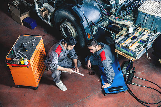 Auto and trucks mechanics Auto and trucks mechanics working on a truck. car mechanic top view stock pictures, royalty-free photos & images