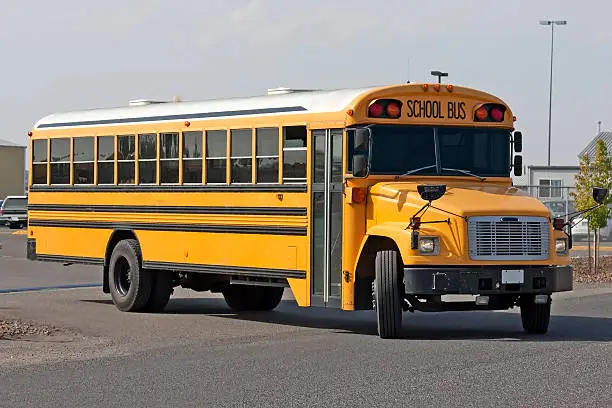 Yellow American Schoolbus pulling out of parking lot