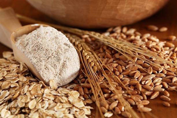 Cereal arrangement Wholegrain flour on wooden spoons, oats and corn. wholegrain flour stock pictures, royalty-free photos & images