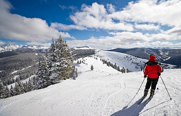 female skier standing with rocky mountains in background - vail eagle county colorado stockfoto's en -beelden
