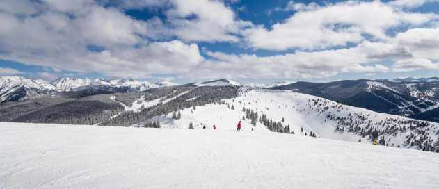Skiing slopes in the foreground and Rocky Mountains in the background. This photograph was taken in Vail, Colorado.