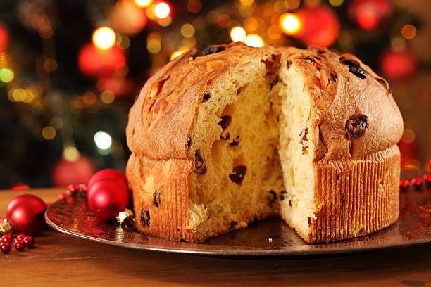 Holiday Panettone cake cut sitting on plate Christmas cake panettone and Christmas decorations. christmas cake stock pictures, royalty-free photos & images