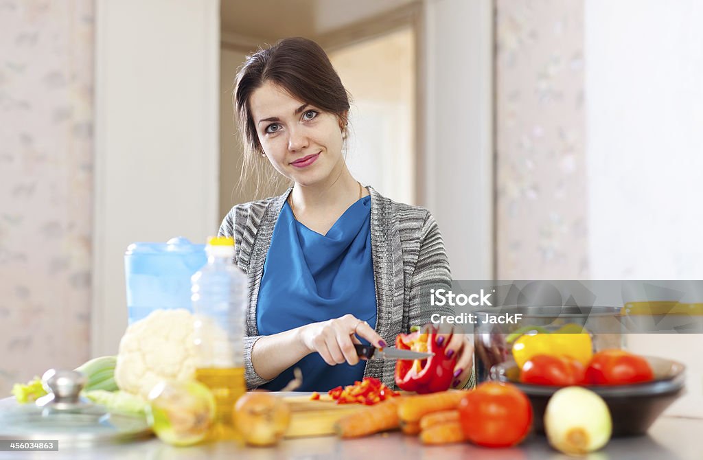 beautiful woman cuts  pepper beautiful woman cuts red pepper at her kitchen 20-29 Years Stock Photo