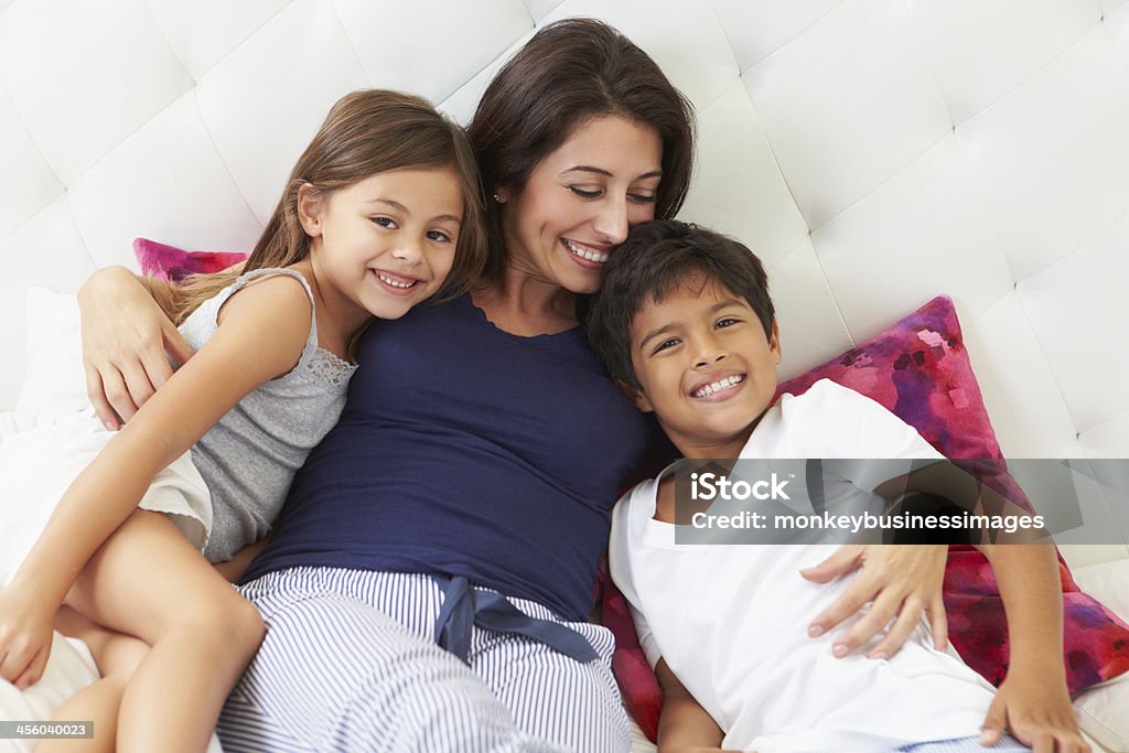Mutter und Kinder im Bett entspannen mit Schlafanzug - Lizenzfrei Familie mit zwei Kindern Stock-Foto