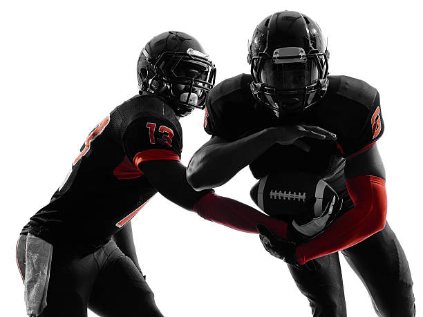 two american football players passing play action silhouette two american football players passing play action in silhouette shadow on white background american football player studio stock pictures, royalty-free photos & images