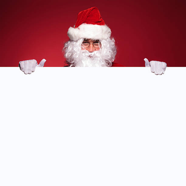 istock santa claus is holding a blank board 456042027