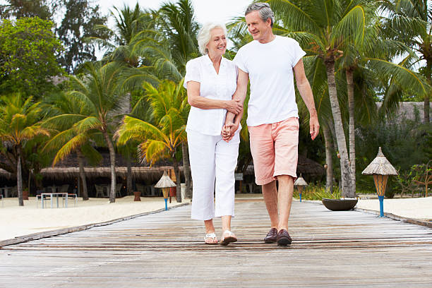 istock Senior Couple Walking On Wooden Jetty 456057105