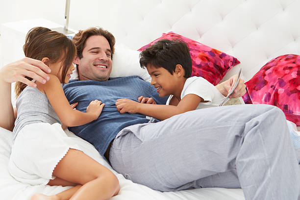 istock Father And Children Relaxing In Bed Together 456062237