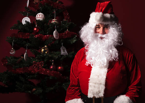 istock santa claus is sitting near a christmas tree 456063061
