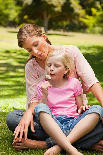 istock Smiling mother and daughter blowing a dandelion 456067295