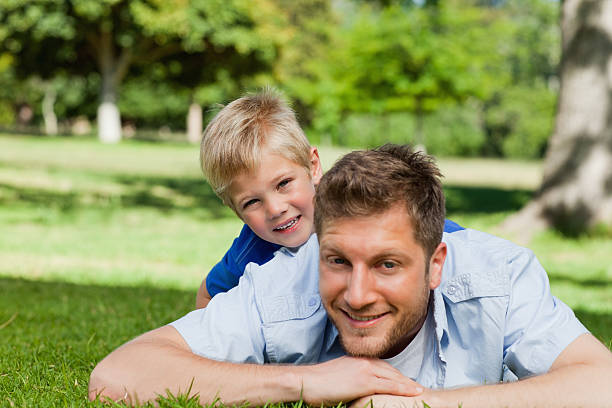 istock Smiling father lying on the grass with his son 456067349