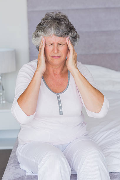 istock Mature woman sitting on her bed has headache 456068377