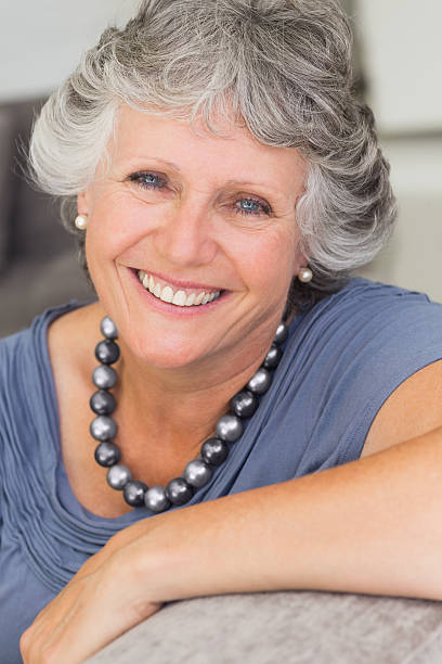 istock Cheerful mature woman sitting on sofa 456068425