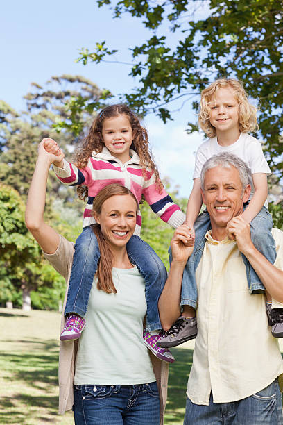istock Two parents carrying their children who are holding hands 456068463