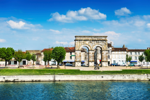 Panoramic View of Arc in Saintes, Poitou-Charentes, France. Visible are many franch traditional building, Charente river, trees and beautiful summer cloudscape over the water.