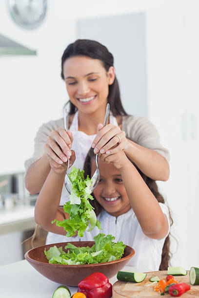 istock Mother and daughter preparing a salad together 456072305