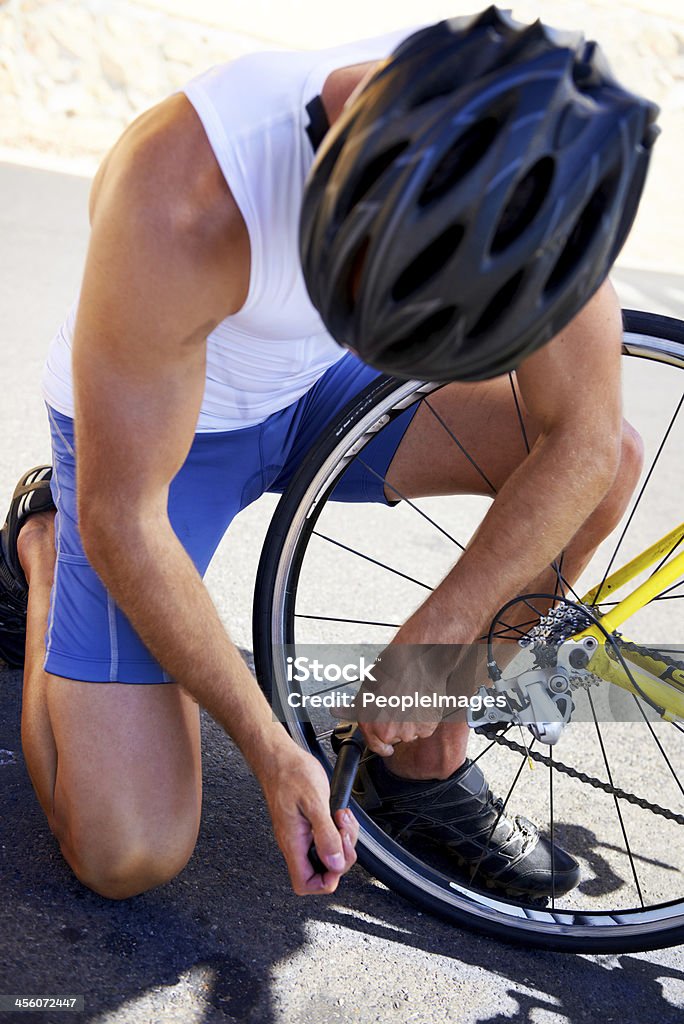 Making sure his bicycle  is ready to ride A young cyclist changing his bike tyre on the roadside Active Lifestyle Stock Photo