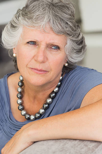 istock Worried mature woman sitting on sofa 456072497