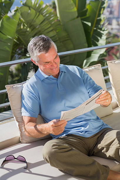 istock Retired man reading newspaper on holidays 456072505