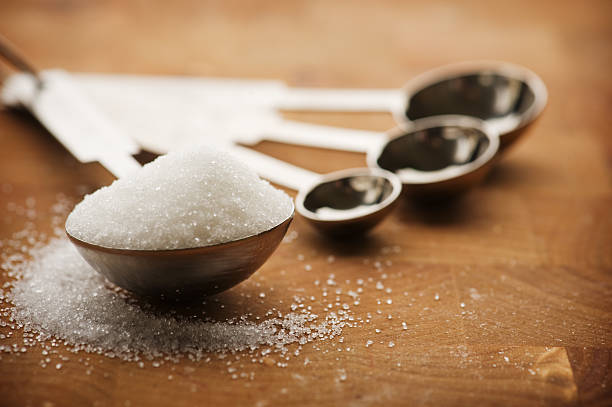 esslöffel mit zuckerraffinade - sugar kitchen utensil measuring spoon spoon stock-fotos und bilder