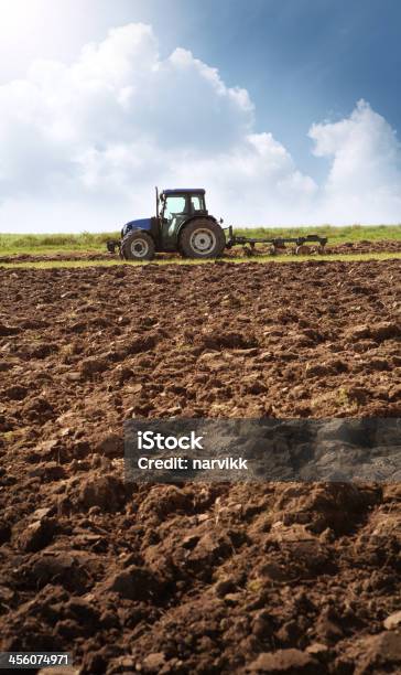 Ploughing Tractor En El Campo De Foto de stock y más banco de imágenes de Agricultor - Agricultor, Arado, Maquinaria