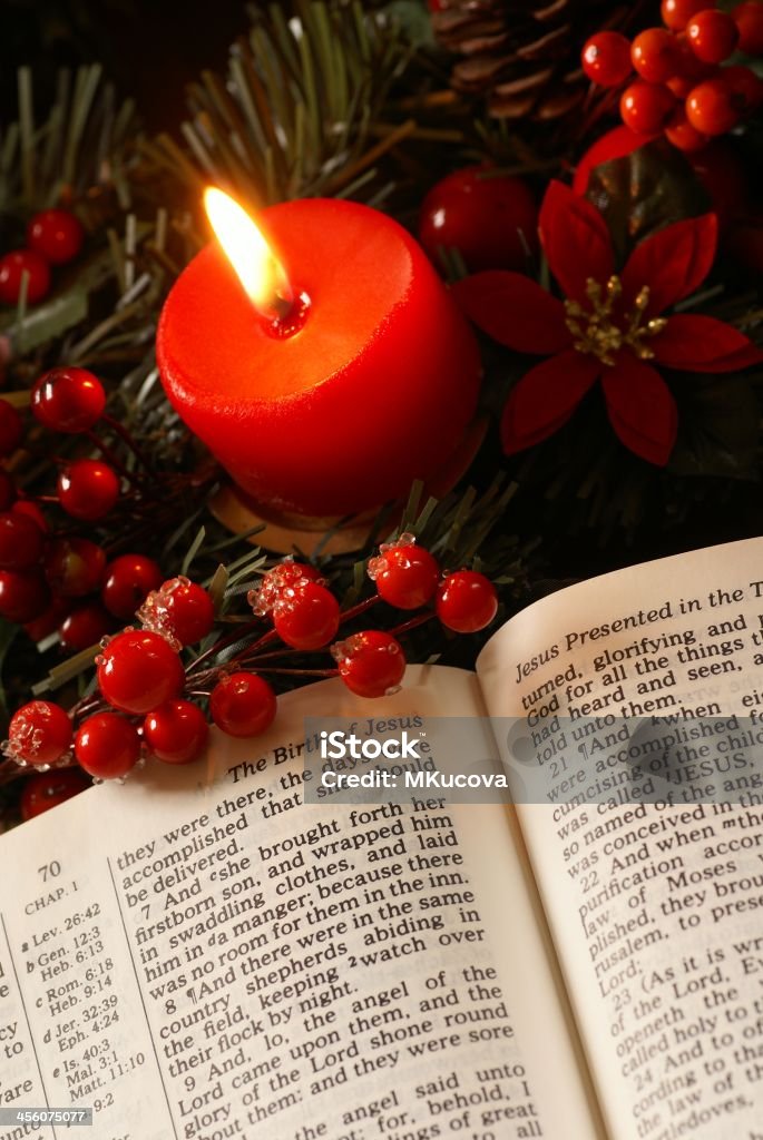 Christmas story Open Bible and candle on advent wreath. Bible Stock Photo