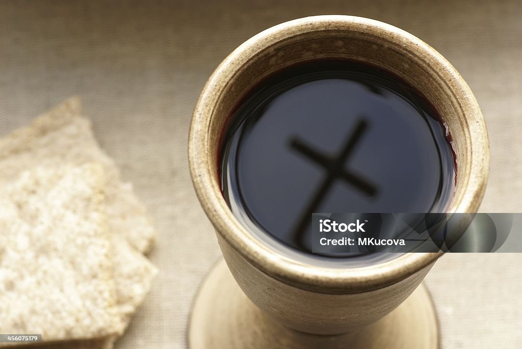 Wine and bread Chalice with wine and bread. Cross shadow in the chalice. Communion Stock Photo