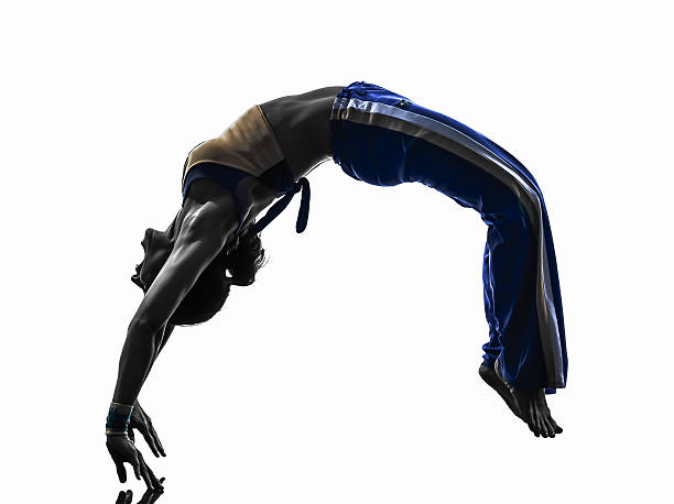 femme silhouette de danseuse danse capoiera un flip arrière - acrobatic activity photos et images de collection
