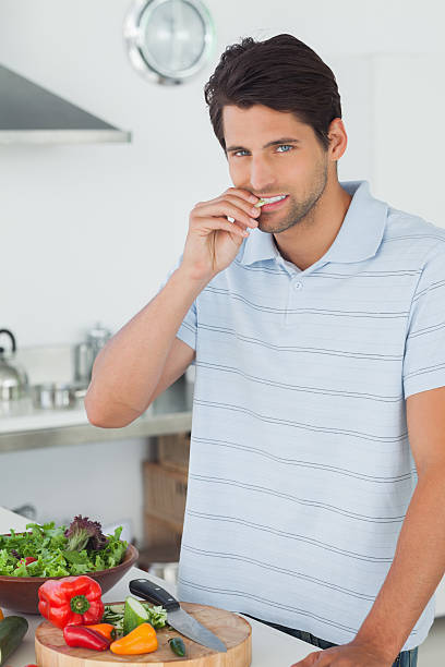 istock Man eating a bit of vegetable 456081197