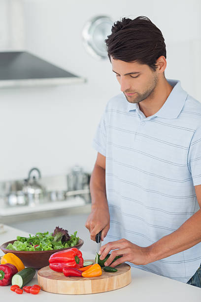 istock Man slicing a courgette in the kitchen 456081199